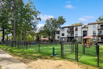 A black fence surrounds a playground in a residential area.